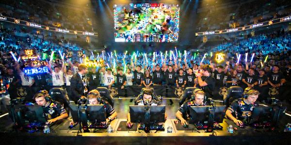 DOTA2国际邀请赛现场，展示选手激烈对抗和观众热情欢呼的场景